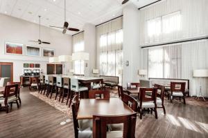 a dining room with tables and chairs and windows at Hampton Inn & Suites Navarre in Navarre