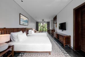 a hotel room with two beds and a television at Coco Island Villa & Hotel Ninh Bình in Ninh Binh