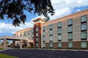 Home2 Suites by Hilton Gulf Breeze Pensacola Area, FL في غولف بريز: مبنى مكتب امامه موقف سيارات