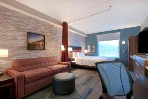 um quarto de hotel com uma cama e um sofá em Home2 Suites by Hilton Gulf Breeze Pensacola Area, FL em Gulf Breeze