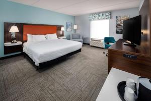 a hotel room with a bed and a flat screen tv at Hampton Inn & Suites Navarre in Navarre