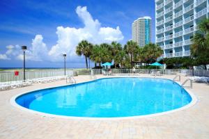 a large swimming pool with a building in the background at The Island House Hotel a Doubletree by Hilton in Orange Beach