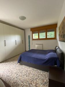 a bedroom with a blue bed and white cabinets at Casa Nostra in Imola