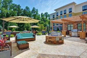 an outdoor patio with a fire pit and umbrella at Homewood Suites By Hilton Poughkeepsie in Poughkeepsie
