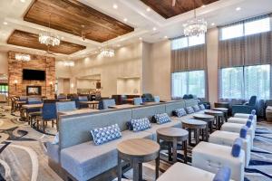 un hall avec des tables et des chaises ainsi qu'une salle d'attente dans l'établissement Homewood Suites By Hilton Poughkeepsie, à Poughkeepsie