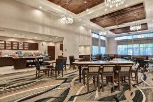 uma sala de jantar com mesas e cadeiras e uma cozinha em Homewood Suites By Hilton Poughkeepsie em Poughkeepsie