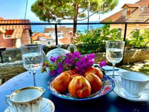 une table avec une plaque de tomates et des verres d'eau dans l'établissement MAD di Mare di Arte Dormire, à Celle Ligure