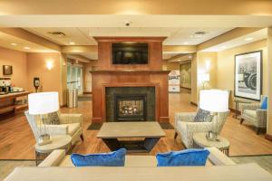 a lobby with a fireplace with chairs and a table at Hampton Inn Presque Isle in Presque Isle