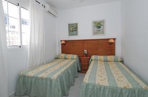 Cama ou camas em um quarto em Apartamentos HC Burriana Playa