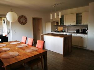 a kitchen and dining room with a wooden table with chairs at Wohnung 13 in Wildeshausen