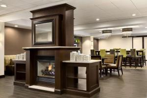 a fireplace in a waiting room with a table and chairs at Hampton Inn Dover in Dover