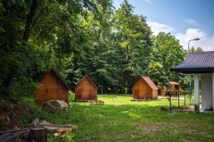 un groupe de petites cabanes en bois dans un champ dans l'établissement Koča sredi gozda, à Kanal