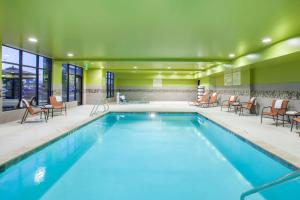 - une piscine dans une chambre d'hôtel avec des chaises et des tables dans l'établissement Hampton Inn & Suites Pasco/Tri-Cities, WA, à West Pasco