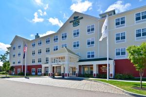 a large white hotel with two flags in front of it at Homewood Suites by Hilton Dover in Dover