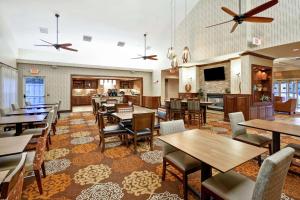 a restaurant with tables and chairs and a kitchen at Homewood Suites by Hilton Dover in Dover