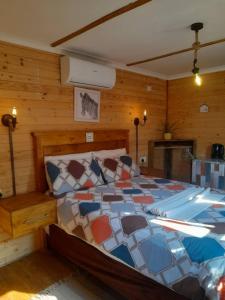 een slaapkamer met een bed in een kamer met houten wanden bij The CabinGuesthouse in Gaborone