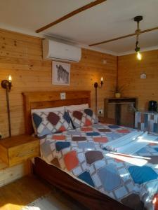 a bedroom with a bed in a room with wooden walls at The CabinGuesthouse in Gaborone