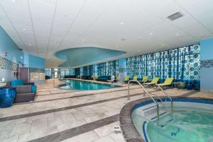 a pool in a hotel lobby with chairs and a swimming pool at Hampton Inn Norwich in Norwich