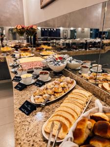 a buffet line with different types of bread and pastries at Hotel Concord in Campo Grande