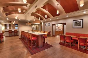 uma grande sala com um bar e mesas e cadeiras em Hampton Inn & Suites Orem/Provo em Orem