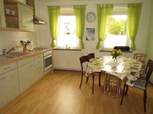 a kitchen with a table and chairs in a kitchen at Ferienwohnung-Heidi in Kirschau