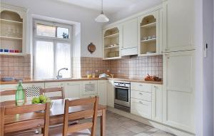 a kitchen with white cabinets and a table and chairs at Villa Mar in Lumbarda