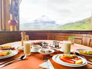 a table with plates of food and milk on it at Hotel Tambopaxi in Machachi