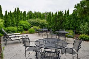 eine Terrasse mit Tischen, Stühlen und Bäumen in der Unterkunft Hampton Inn & Suites by Hilton Plymouth in Plymouth