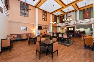una grande stanza con tavoli, sedie e un camino di Hampton Inn & Suites by Hilton Plymouth a Plymouth