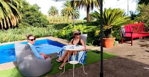 dos mujeres sentadas en una mesa junto a una piscina en Finca La Principal, en Breña Alta