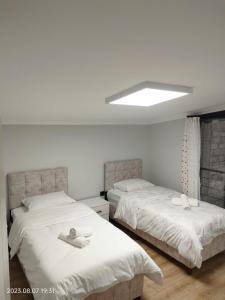 2 camas en una habitación con paredes blancas en LEYLİ GABAN VİLLA en Çaykara
