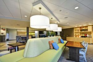 Home2 Suites By Hilton Rapid City في رابيد سيتي: غرفة معيشة مع أريكة خضراء وطاولة