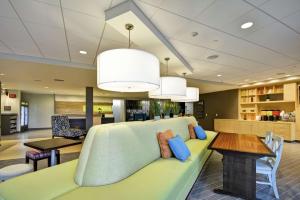 拉皮德城Home2 Suites By Hilton Rapid City的客厅里有一张绿色的沙发和一张桌子