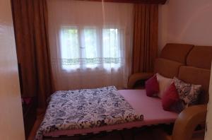 a small bedroom with a bed and a window at Family house in Visoko
