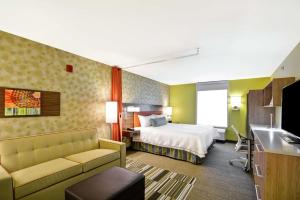 a hotel room with a bed and a couch at Home2 Suites By Hilton Rapid City in Rapid City