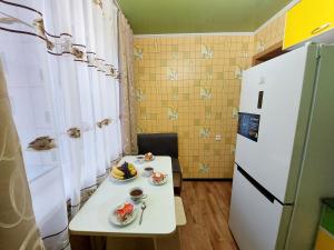eine kleine Küche mit einem weißen Tisch und einem Kühlschrank in der Unterkunft Комфортная квартира с удобным расположением in Līsakovsk