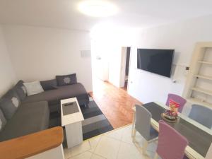 a living room with a couch and a tv at Apartmani Rudelj in Makarska