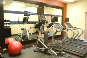 a gym with several tread machines and a mirror at Hampton Inn & Suites Redding in Redding