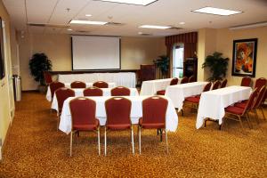 una sala de conferencias con mesas y sillas blancas y una pantalla en Hampton Inn & Suites Redding, en Redding