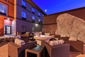 eine Terrasse mit Stühlen und Tischen sowie ein Gebäude in der Unterkunft Hampton Inn & Suites Bend in Bend