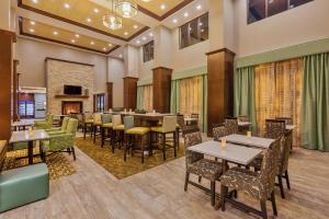 a restaurant with tables and chairs and a fireplace at Hampton Inn & Suites Bend in Bend