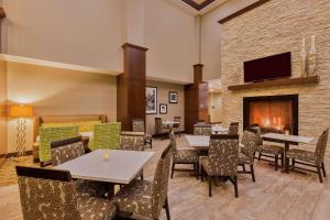 a restaurant with tables and chairs and a fireplace at Hampton Inn & Suites Bend in Bend