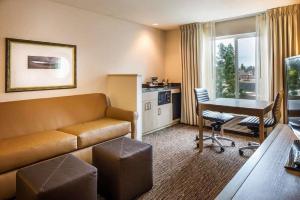 a hotel room with a couch and a table and a kitchen at DoubleTree by Hilton Bend in Bend