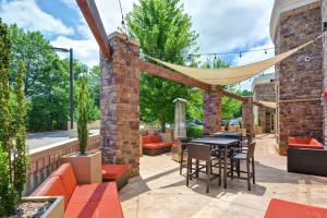 a patio with a table and chairs and a hammock at Hampton Inn & Suites Crabtree in Raleigh