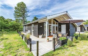 una casa con terrazza in legno e ombrellone di Amazing Home In Nykbing Sj With Wifi a Nykøbing Sjælland