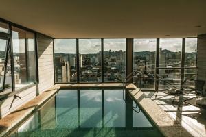 a swimming pool in a building with a view of the city at Mulen Hotel Tandil in Tandil