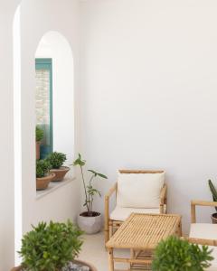 Zimmer mit einem Stuhl, einem Tisch und Topfpflanzen in der Unterkunft Royal-Ma Resort in Perástra