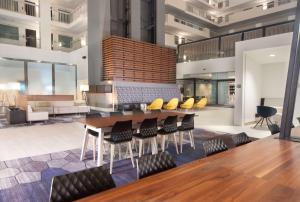 罗利Embassy Suites by Hilton Raleigh Crabtree的有桌子和椅子的餐厅