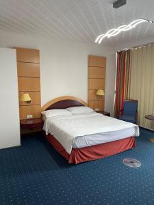 a hotel room with a large bed and two chairs at Eventhaus in Panzweiler