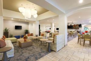 a lobby with tables and chairs and a restaurant at Hilton Garden Inn Raleigh-Durham/Research Triangle Park in Durham